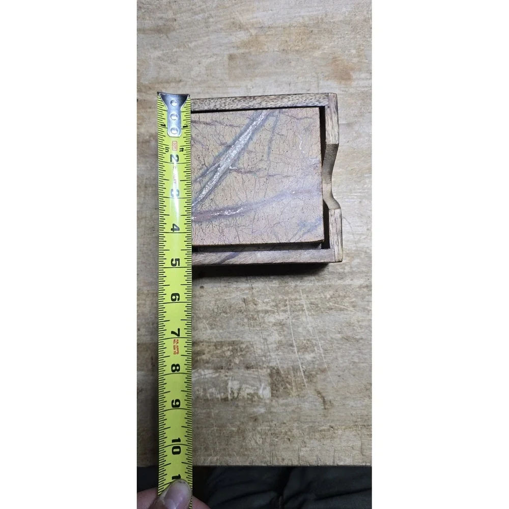 square marble coaster set holder in a wooden base.